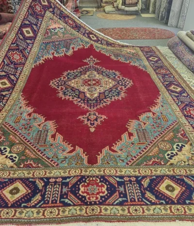 Antique hand-knotted Tabriz rug, Size: 314 x 230 cm, A complex, multi-layered geometric star medallion that serves as the focal point, symbolizing the "Sun" or "Center of the Universe, deep crimson red, navy blue & turquoise.v