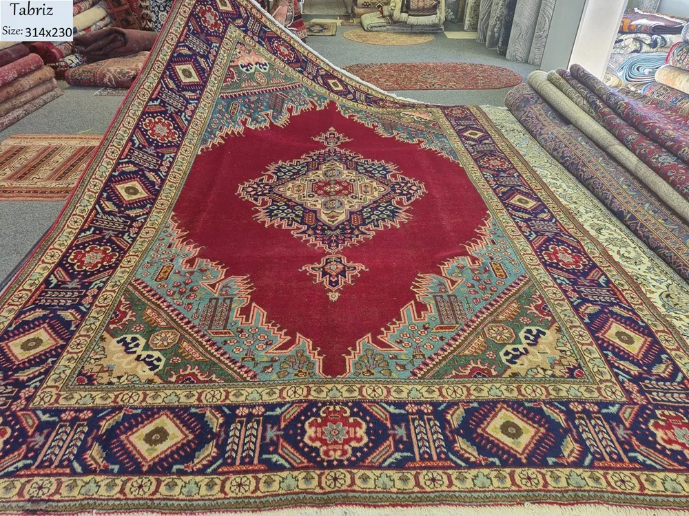 Antique hand-knotted Tabriz rug, Size: 314 x 230 cm, A complex, multi-layered geometric star medallion that serves as the focal point, symbolizing the "Sun" or "Center of the Universe, deep crimson red, navy blue & turquoise.v