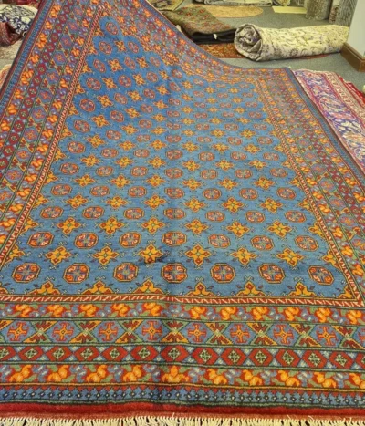 Hand-Knotted Afghan Bokhara, Size: 294 x 196 cm, in azure blue field with a traditional “gol” (elephant’s foot) pattern, High-quality wool on a durable cotton foundation.
