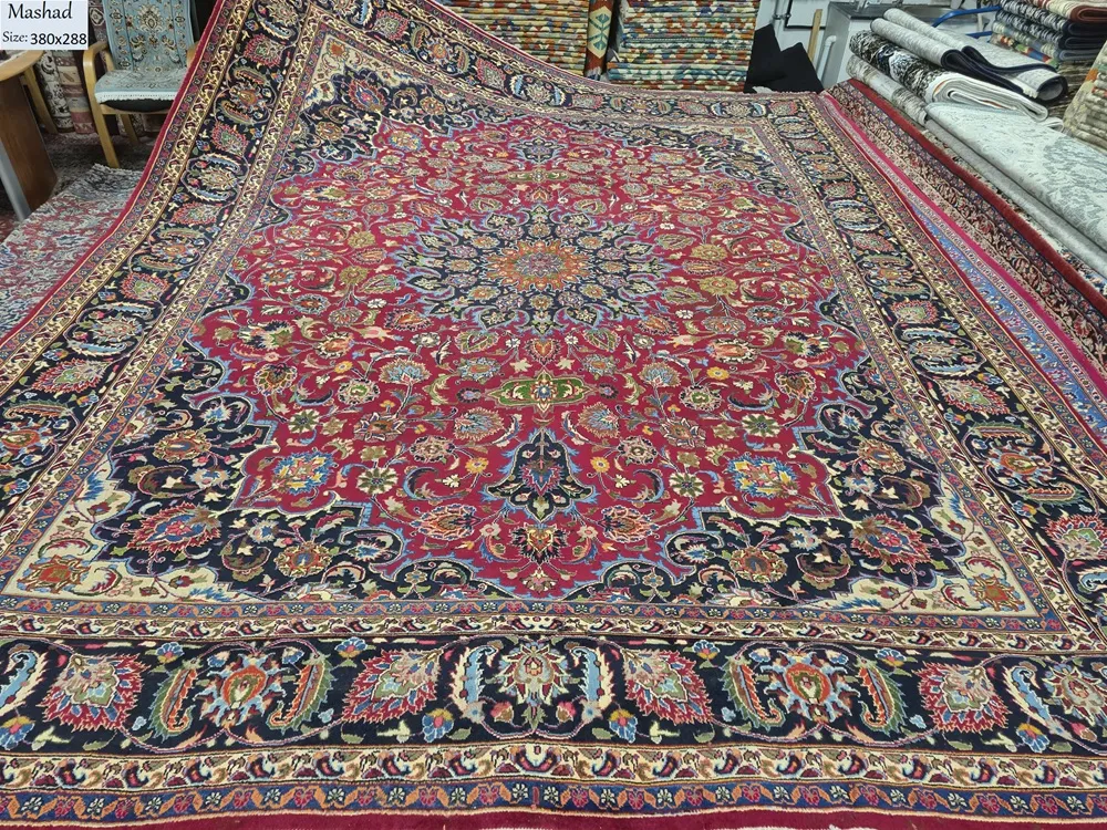 Authentic Hand-Knotted Mashad Rug, Size: 380 x 288 cm, high-quality, soft wool, Intricate Shah Abbasi floral motifs with a detailed central medallion, cochineal red field and midnight blue borders.