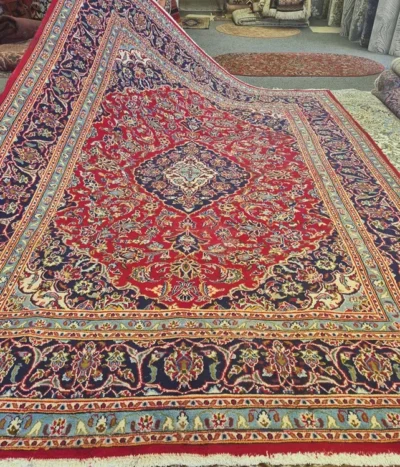 Hand-knotted Persian Kashan carpet, Size: 295 x 200 cm, Traditional Central Medallion with intricate floral motifs, royal red and deep indigo blue with sky blue accent color, high-quality wool on a cotton foundation.
