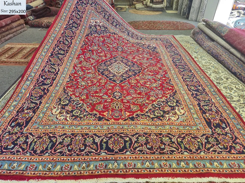 Hand-knotted Persian Kashan carpet, Size: 295 x 200 cm, Traditional Central Medallion with intricate floral motifs, royal red and deep indigo blue with sky blue accent color, high-quality wool on a cotton foundation.