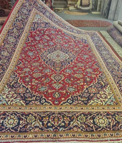 Hand-knotted Persian Kashan rug, Size: 298 x 216 cm, Traditional Central Medallion with intricate floral motifs, Crimson Red, Navy Blue, high-quality wool on a cotton foundation.