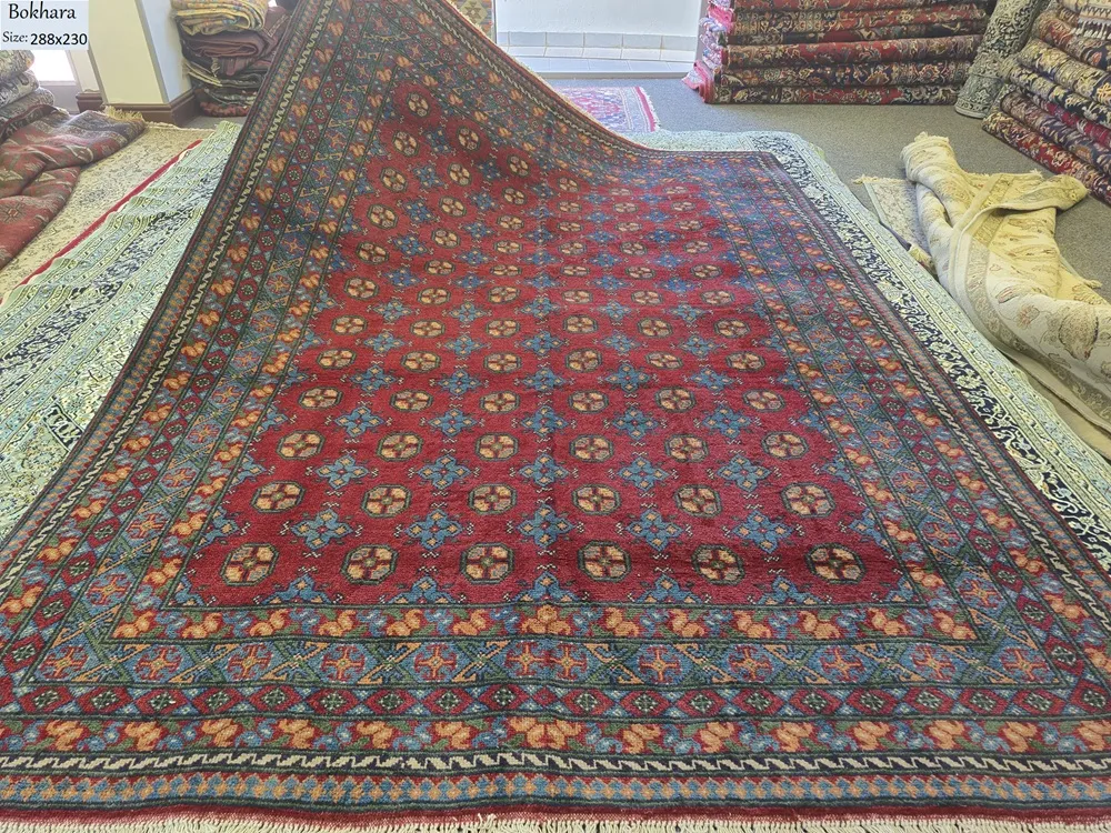 Handmade Afghan Bokhara, Size: 288 x 230 cm, in rich madder red with a traditional “gol” (elephant’s foot) pattern, High-quality wool on a durable cotton foundation.