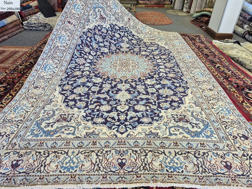 Persian handmade Nain rug, Size: 295 x 190 cm, second hand, central medallion and intricate floral motifs in a navy and ivory color. R 20 000 valuation certificate.