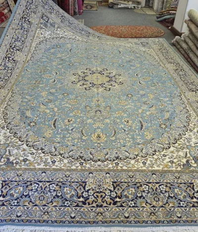 This exquisite 400 x 300 cm Isfahan rug features a classic central medallion layout, framed by an elegant navy blue border and a soft ivory/light blue field. Inspired by the Safavid-era tilework of Isfahan’s grand mosques, the design utilizes flowing Shah Abbasi floral motifs and complex arabesque vines.