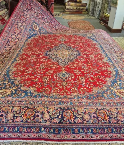 Premium Kashan Persian Rug is an authentic, hand-knotted masterpiece featuring a striking central medallion set against a vibrant crimson field. Size: 385 x 300 cm