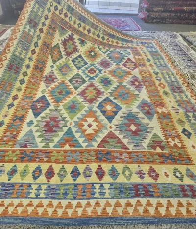 Authentic flat-weave Kilim, Size: 298 x 198 cm, diamond medallion pattern with stepped edges (symbolic of protection or fertility. Mix of terracotta, turquoise, forest green, and golden yellow.