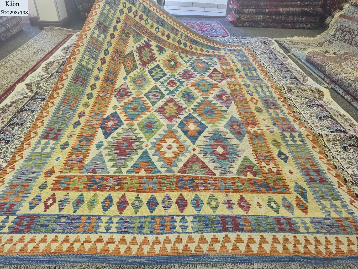 Authentic flat-weave Kilim, Size: 298 x 198 cm, diamond medallion pattern with stepped edges (symbolic of protection or fertility. Mix of terracotta, turquoise, forest green, and golden yellow.