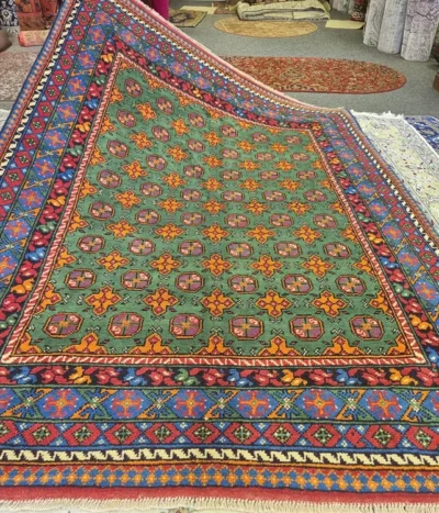 Hand-knotted Bokhara rug, Size: 234 x 168 cm, lush emerald green symmetrical field of star-shaped and cruciform medallions, surrounded by a complex "running dog" and diamond-lattice border, High-quality wool on a durable cotton foundation.