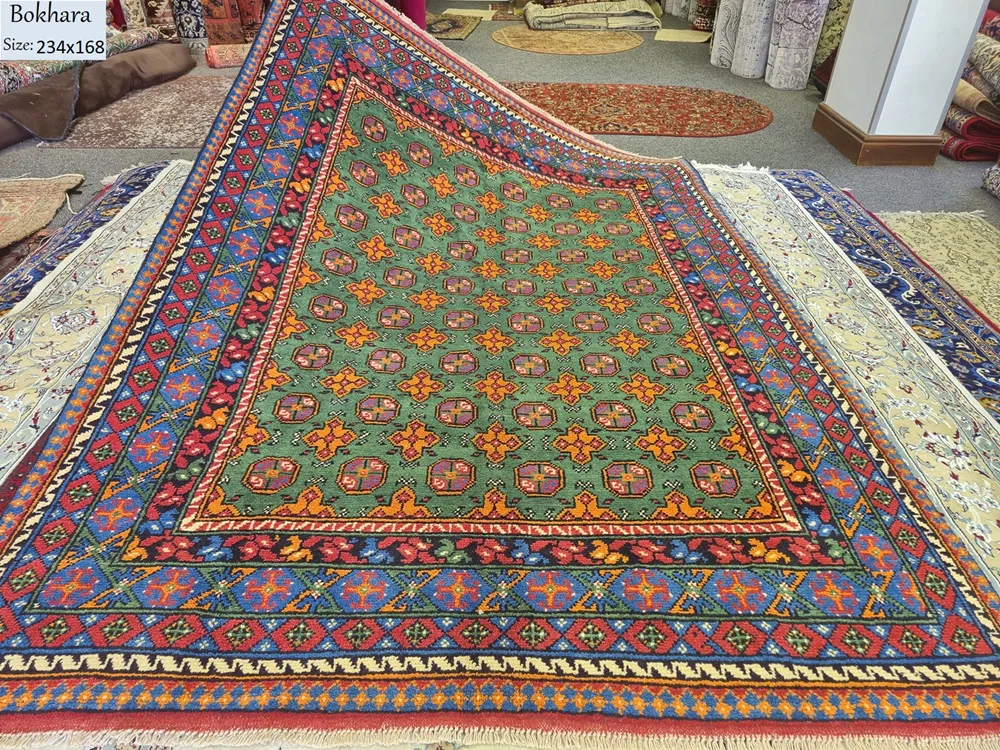 Hand-knotted Bokhara rug, Size: 234 x 168 cm, lush emerald green symmetrical field of star-shaped and cruciform medallions, surrounded by a complex "running dog" and diamond-lattice border, High-quality wool on a durable cotton foundation.