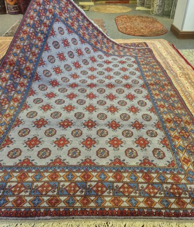 Handmade Bokhara (Tribal Geometric), Size: 243 x 168 cm, steel-blue field combined with the multi-colored geometric borders, Dense plush wool pile with a soft handle, characteristic of high-quality hand-knotted pieces.