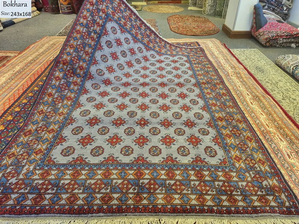 Handmade Bokhara (Tribal Geometric), Size: 243 x 168 cm, steel-blue field combined with the multi-colored geometric borders, Dense plush wool pile with a soft handle, characteristic of high-quality hand-knotted pieces.