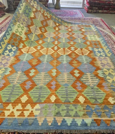Handwoven Kilim rug, Size: 290 x 199 cm, Traditional geometric diamond motifs. terracotta and ochre, balanced by cool sage greens, slate blues, and soft lavender accents.