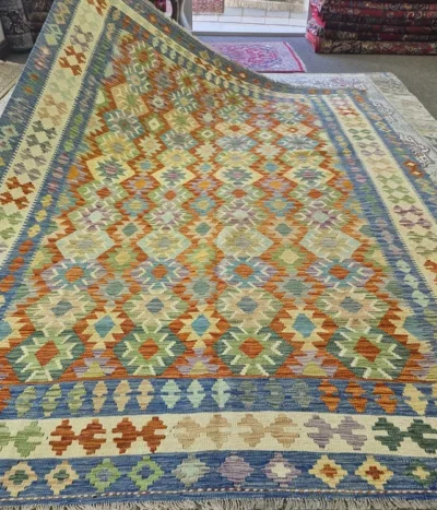 Hand-Woven Afghan Kilim, Size: 298 x 216 cm, Traditional geometric diamond medallions, vibrant harmony of terracottas, warm oranges, soft greens, muted purples, and striking lapis blue accents on a classic cream ground, 100% Hand-spun Wool on a Wool foundation.