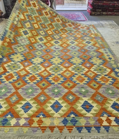 Hand-Woven Geometric Kilim, Size: 302 x 203 cm, Traditional diamond motifs, masterfully balances vibrant terracotta orange & warm gold with accents of sage green & indigo blue. 100% Premium Wool